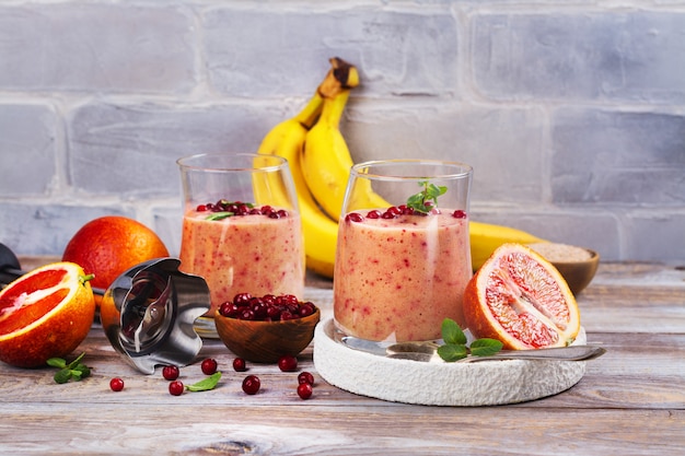 Gesunder erneuernder rosa Smoothie mit Apfel, roten Orangen, Preiselbeere und Kleie