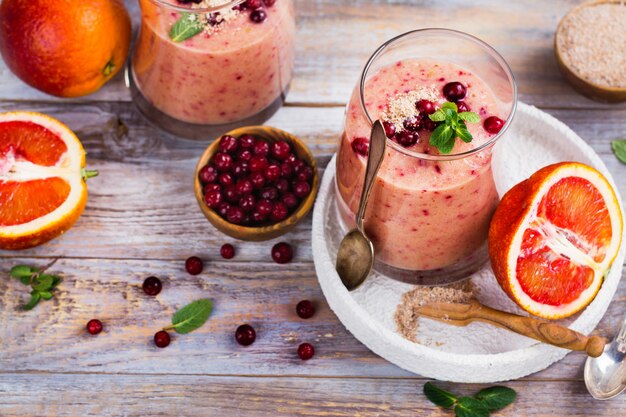 Gesunder erneuernder rosa Smoothie mit Apfel, roten Orangen, Preiselbeere und Kleie