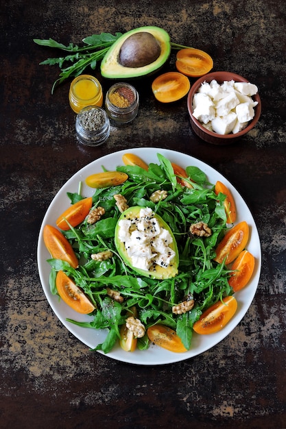 Gesunder Fitness-Salat mit Rucola, Avocado, Feta und gelben Kirschtomaten. Rezept für Salat mit Avocado, Rucola und Weißkäse. Vegetarischer nahrhafter Salat. Keto-Diät.