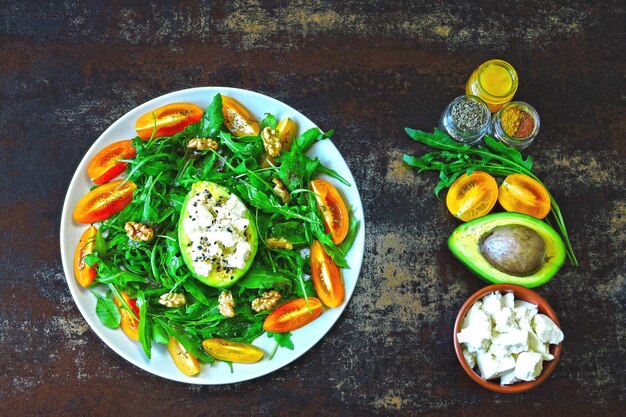 Gesunder Fitness-Salat mit Rucola, Avocado, Feta und gelben Kirschtomaten.