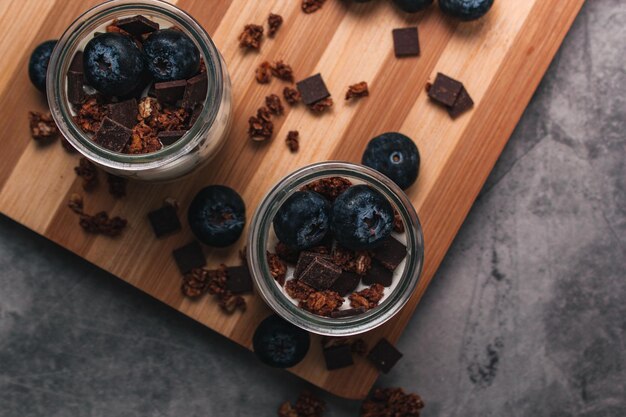 Gesunder Frühstücksjoghurt mit Beeren und Müsli in Gläsern