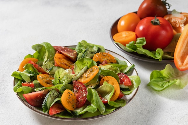 Gesunder Gemüsesalat aus frischem Gemüse von Tomaten, Gurken, Zwiebeln, Spinat, Salat auf einem Teller. Diät-Menü. Sicht von oben.