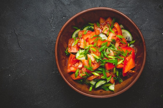 Gesunder Gemüsesalat aus frischen Tomaten, Gurken, Zwiebeln, Spinat, Salat