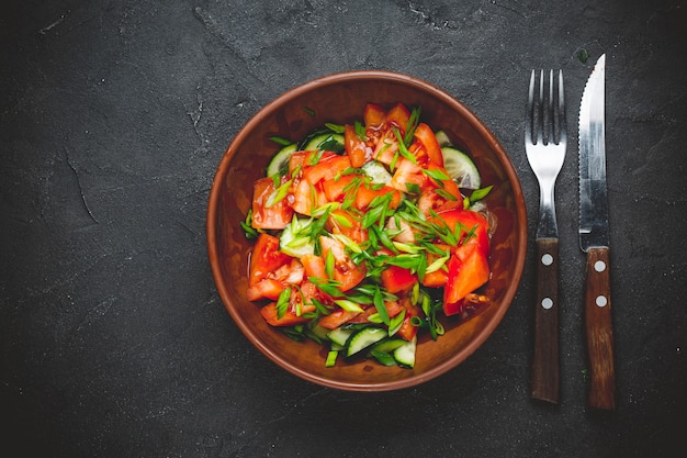 Gesunder Gemüsesalat aus frischen Tomaten, Gurken, Zwiebeln, Spinat, Salat