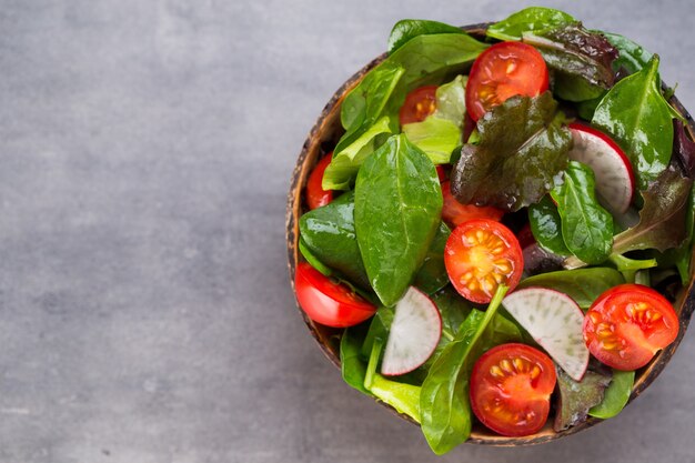 Gesunder Gemüsesalat aus frischen Tomaten, Spinat, Salat und Radieschen.