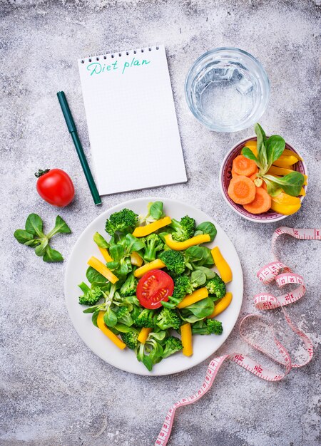 Foto gesunder gemüsesalat, wasser und maßband