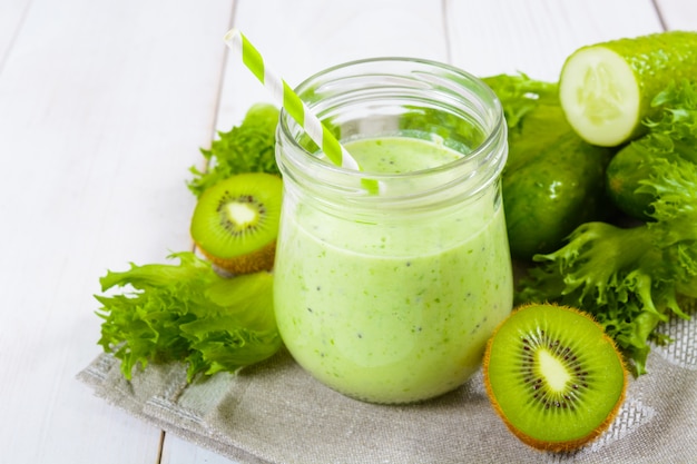 Gesunder grüner Smoothie im Glas mit Gurke, Kiwi, Salat