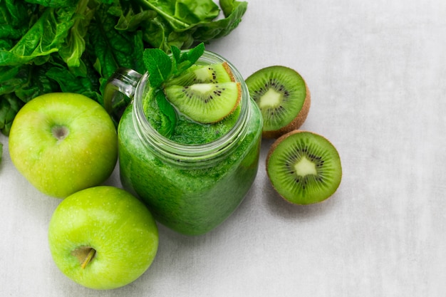 Gesunder grüner Smoothie mit Spinat und Kiwi in einem Glasbecher