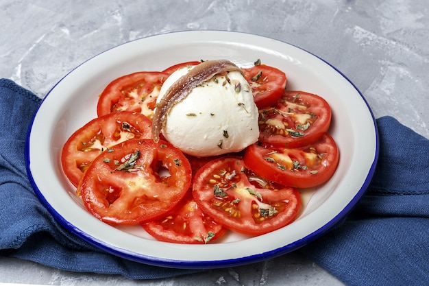 Gesunder hausgemachter Tomatensalat mit Mozzarella, Sardellen und Oregano