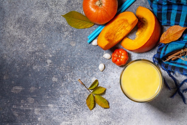 Gesunder Herbst-Kürbis-Smoothie mit Zimt im Glas auf einer Steinarbeitsplatte Draufsicht