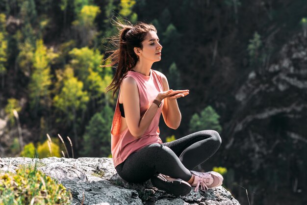 Gesunder Lebensstil und Entspannungskonzept. Yoga an der frischen Luft. Glückliche Frau, die Yogaübungen macht. Meditation und Entspannung. Eine Frau, die Yoga in den Bergen praktiziert. Eine Frau meditiert in der Natur