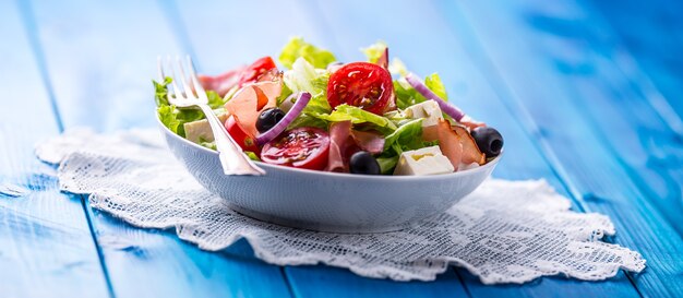 Gesunder mediterraner Salat Oliven Tomaten Parmesan und Prosciutto