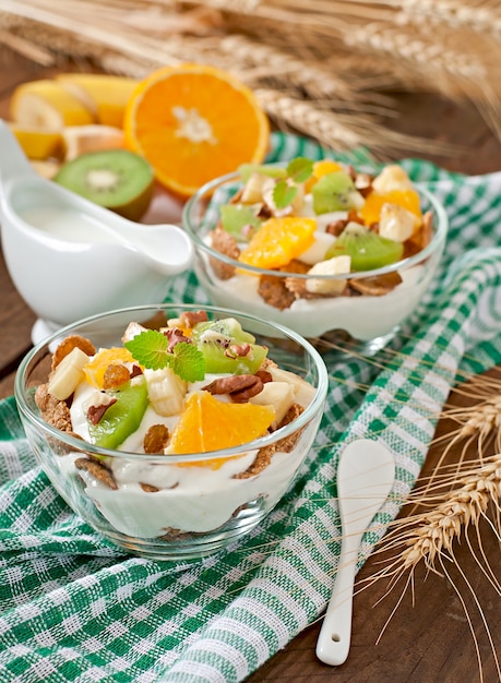 Gesunder Nachtisch mit Müsli und Frucht in einer Glasschüssel auf dem Tisch