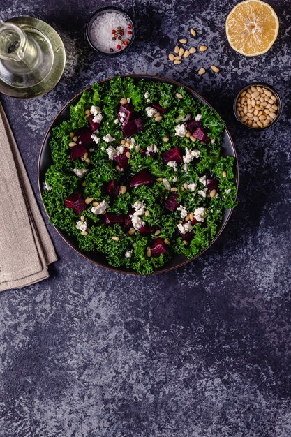 Gesunder roher Grünkohl- und Rote-Bete-Salat mit Feta-Käse und Pinienkernen. Ansicht von oben.