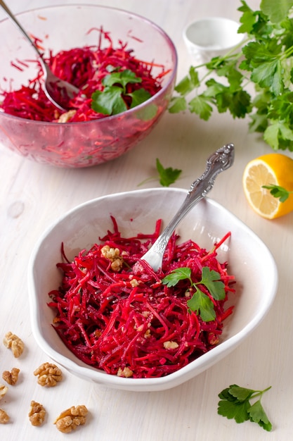 Gesunder roher Rote-Bete-Wurzeln Salat des strengen Vegetariers mit Karotte und Walnüssen in einer Schüssel