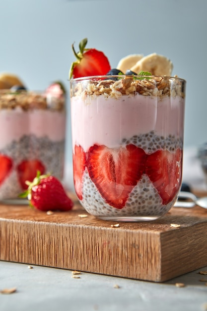 Gesunder rosa Smoothie in Gläsern mit natürlichen Früchten Erdbeere, Banane, Blaubeere