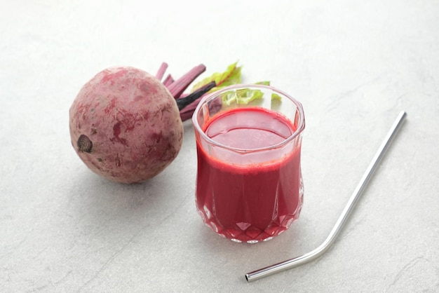 Gesunder Rote-Bete-Saft serviert im Glas mit frischer Rote-Bete auf dem Tisch, Nahaufnahme ausgewählter Fokus