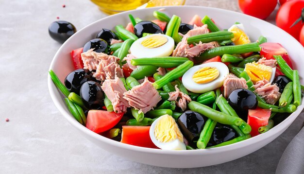 gesunder Salat aus Thunfisch, grünen Bohnen, Tomaten, Eiern, gekochten Kartoffeln, schwarzen Oliven