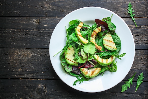 Gesunder Salat gegrillte Avocado und grüne Blätter