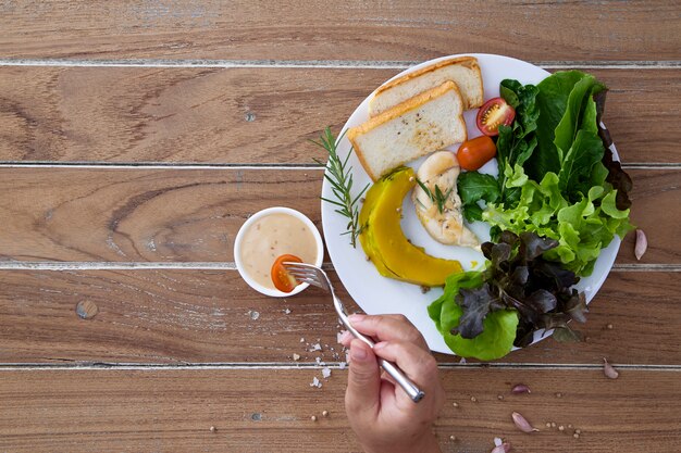 Gesunder Salat in der weißen Platte auf Holztisch-Raum für das Entwerfen von gesunden Lebensmittelkonzepten