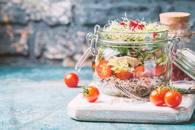 Gesunder Salat in einem Glas mit Quinoa, Gemüse und Grün - gesundes Essen oder Diätkonzept