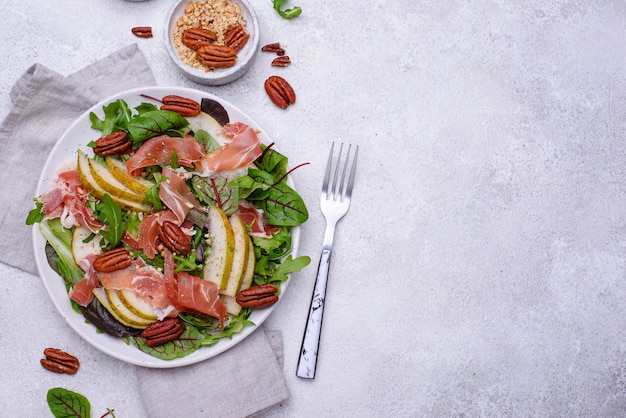 Gesunder Salat mit Birnen-, Schinken- und Pekannüssen