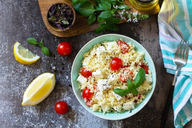 Gesunder Salat mit Couscous-Tomaten-Feta-Käse-Basilikum-Chili-Pfeffer und Olivenöl Draufsicht