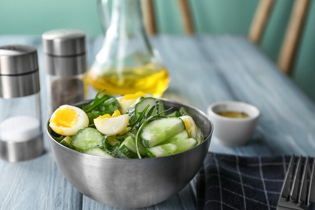 Gesunder Salat mit Gurken und Eiern in einer Schüssel auf dem Tisch