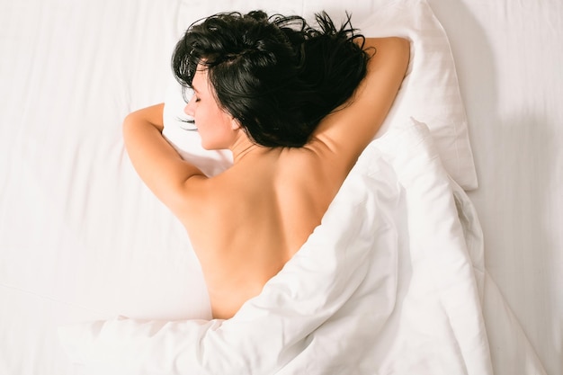 Gesunder Schlaf Erholung Frau ruht im gemütlichen Bett mit weißen Laken