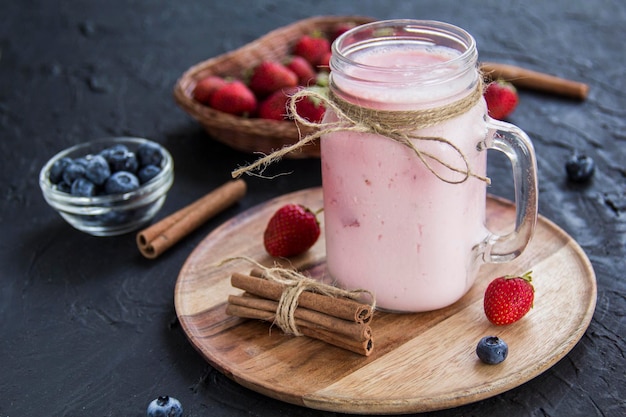 Gesunder Smoothie aus frischen Sommerbeeren. Kreative stimmungsvolle Dekoration