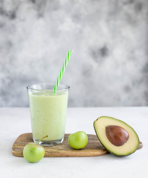 Gesunder Smoothie mit Avocadogurkenapfel in einem Glas mit einem Strohhalm