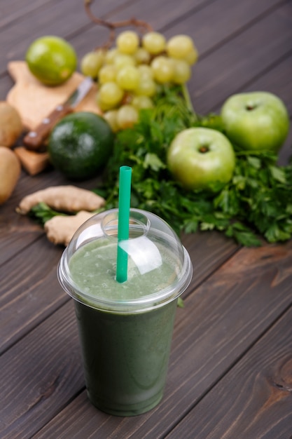 Gesunder Smoothie mit grünem Gemüse und Obst liegen auf dem Tisch