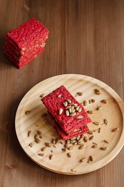 Gesunder Snack-Cracker oder Keks mit Samen und Rote-Bete-Draufsicht auf einer Steinplatte mit Haferflocken auf Holzhintergrund, gesundes Essen oder Diätkonzept