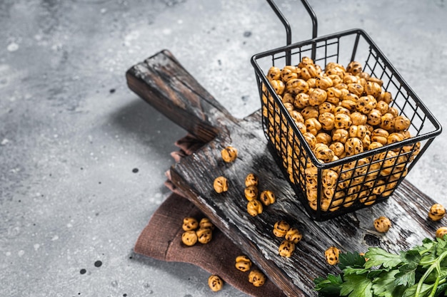 Gesunder Snack geröstete würzige Kichererbsen in einem Korb. Grauer Hintergrund. Ansicht von oben. Platz kopieren.