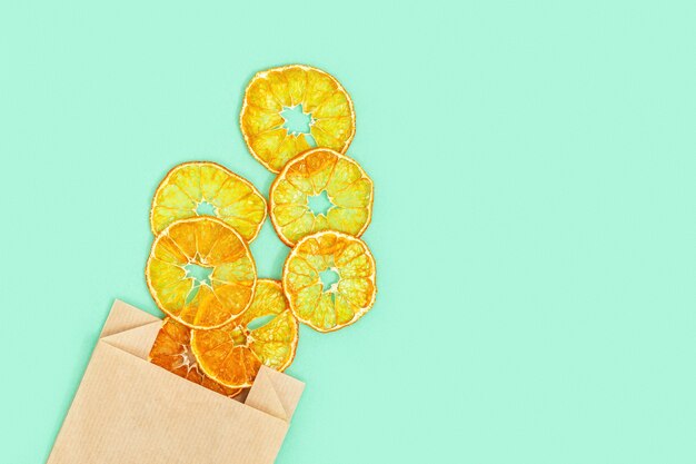 Gesunder Snack. Hausgemachte dehydrierte Fruchtchips der Mandarine. Trockene Mandarine in Papierverpackung.