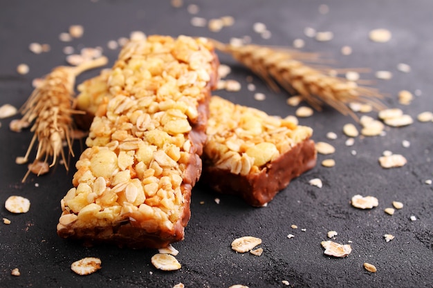 Gesunder Snack, Müsliriegel mit Rosinen und Nüsse auf einem schwarzen Hintergrund