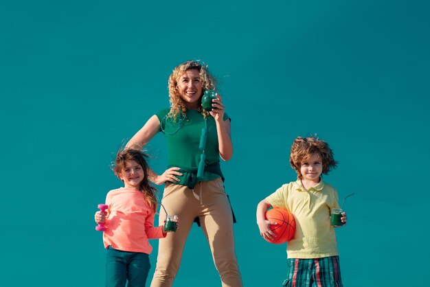 Foto gesunder sportlicher familienlebensstil, glückliche familienmutter und kind, die auf himmelshintergrund stehen, muttertochter