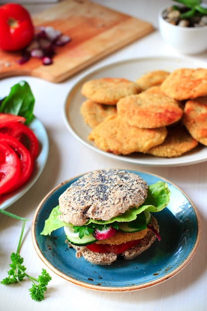 Gesunder veganer Burger mit Kichererbsenstückchen und Vollkornbrötchen mit Sesam und Mohn