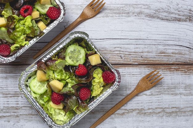 Gesunder Veganer Salat zum Mitnehmen in Aluminiumbehältern oder zur Lieferung von Lebensmitteln.