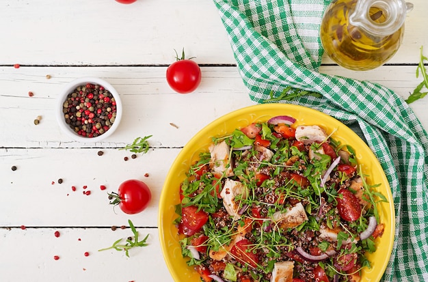 Gesundes Abendessen. Salatschüssel Mittagessen mit gegrilltem Hähnchen und Quinoa, Tomaten, Paprika, roten Zwiebeln und Rucola. Ansicht von oben