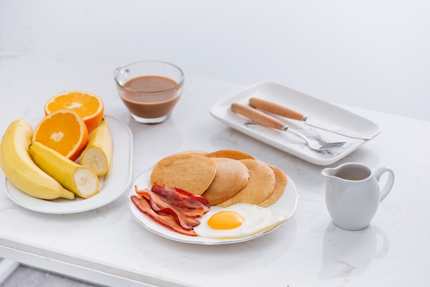 Gesundes amerikanisches Frühstück mit Eierspeck und Pfannkuchen
