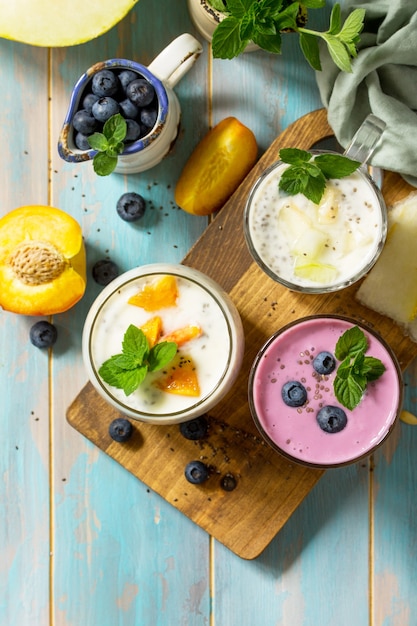 Gesundes Chia-Set Pudding im Glas mit Blaubeere mit Melone und Pfirsich Draufsicht flach