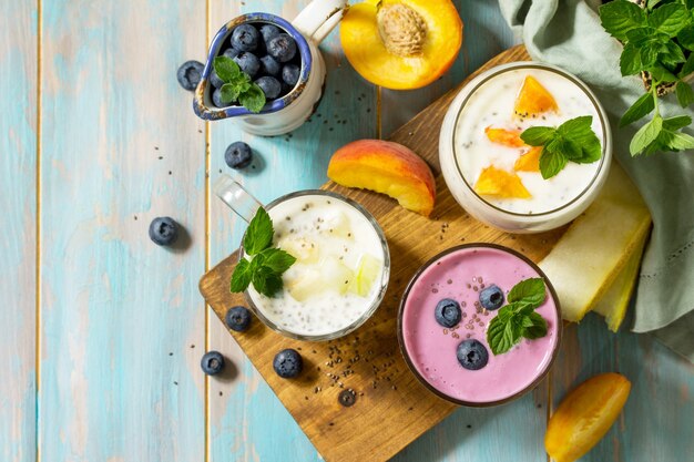 Gesundes Chia-Set Pudding im Glas mit Blaubeere mit Melone und Pfirsich Draufsicht flach