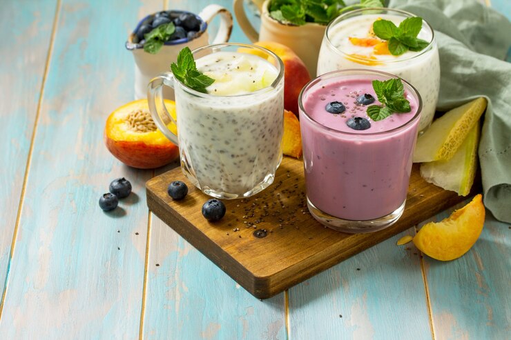 Gesundes Chia-Set Pudding in einem Glas mit Blaubeere mit Melone und Pfirsich auf Holzküchentisch