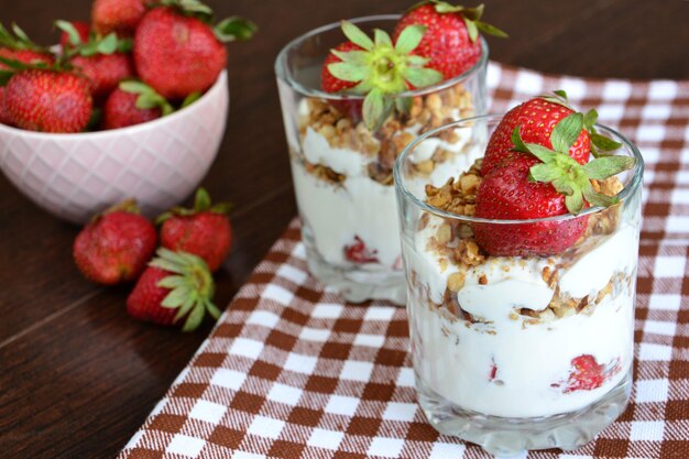 gesundes dessert mit joghurt, müsli und erdbeere in trinkgläsern, nahaufnahme