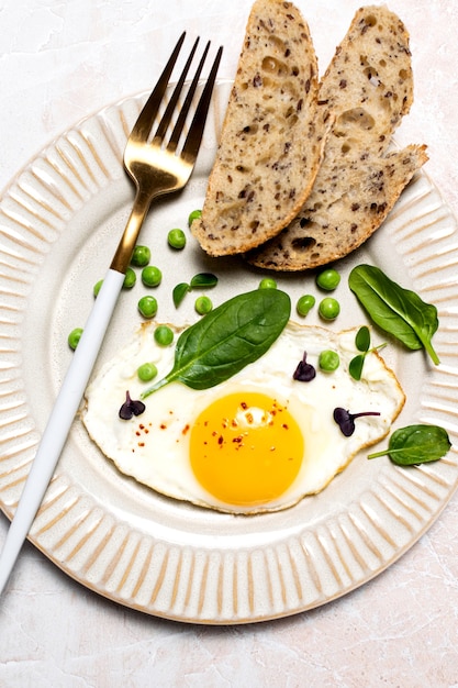 Gesundes Eierfrühstück mit Spinat und Microgreens, Draufsicht auf Marmortisch