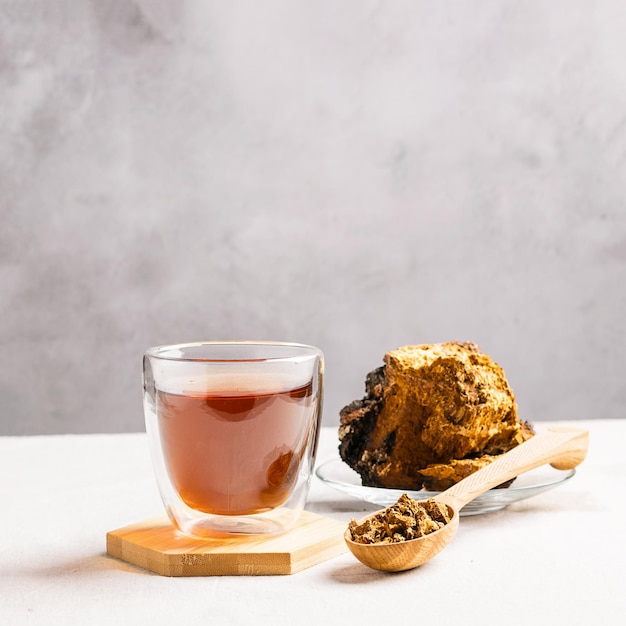 Gesundes Ernährungskonzept Trendige Essensgetränke Medizinischer gesunder Tee aus Waldpilz in Glasbecher auf dem Küchentisch