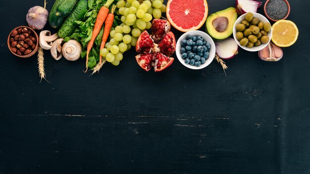 Gesundes Essen Clean Eating Auswahl Gemüse Früchte Nüsse Beeren und Pilze Petersilie Gewürze Auf schwarzem Hintergrund Freier Platz für Text