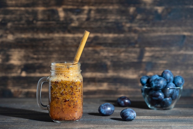 Gesundes Essen, Essen, Diät und vegetarisches Konzept - Glas Saft-Smoothie-Shake aus frischer Pflaume auf einem Vintage-Holztisch. Bio gesundes Essen und Trinken. Bio-Diät. Platz kopieren