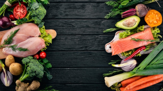 Gesundes Essen Fischfleisch und Gemüse auf dunklem Holzhintergrund Draufsicht Kopierbereich